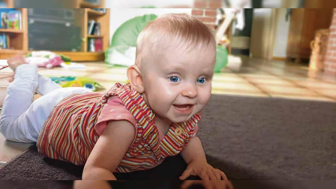 Der Katheter in Merle Reichs Bauch hindert sie nicht daran, auf dem Bauch robbend die Welt zu erkunden. Foto: Familie Reich