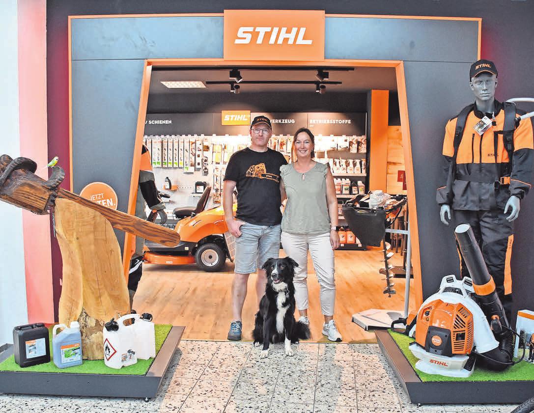 Birgit und Mirko Denker-Gosch stehen mit Hund Buddy vor dem Eingang zum repräsentativen neuen „Stihl“-Shop. Foto: Graap