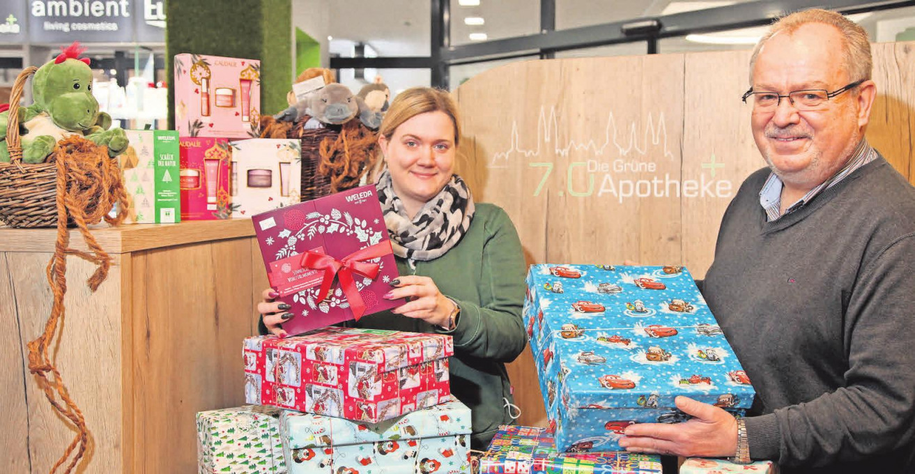 Seit Jahren beteiligt sich Dr. Rudi Alisch an der Aktion „Weihnachten im Schuhkarton“. Jasmin Böttcher, Mitarbeiterin der Apotheke, zeigt, dass es in der Apotheke auch viele Geschenkartikel gibt. Foto: JHP